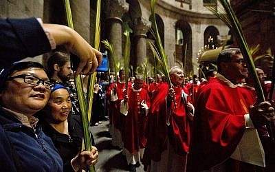 Catholic priests carry palm fronds at the Church of the Holy Sepulcher, traditionally believed by many Christians to be the site of the crucifixion and burial of Jesus, in Jerusalem's Old City, April 14, 2019. (AP Photo/ Sebastian Scheiner)