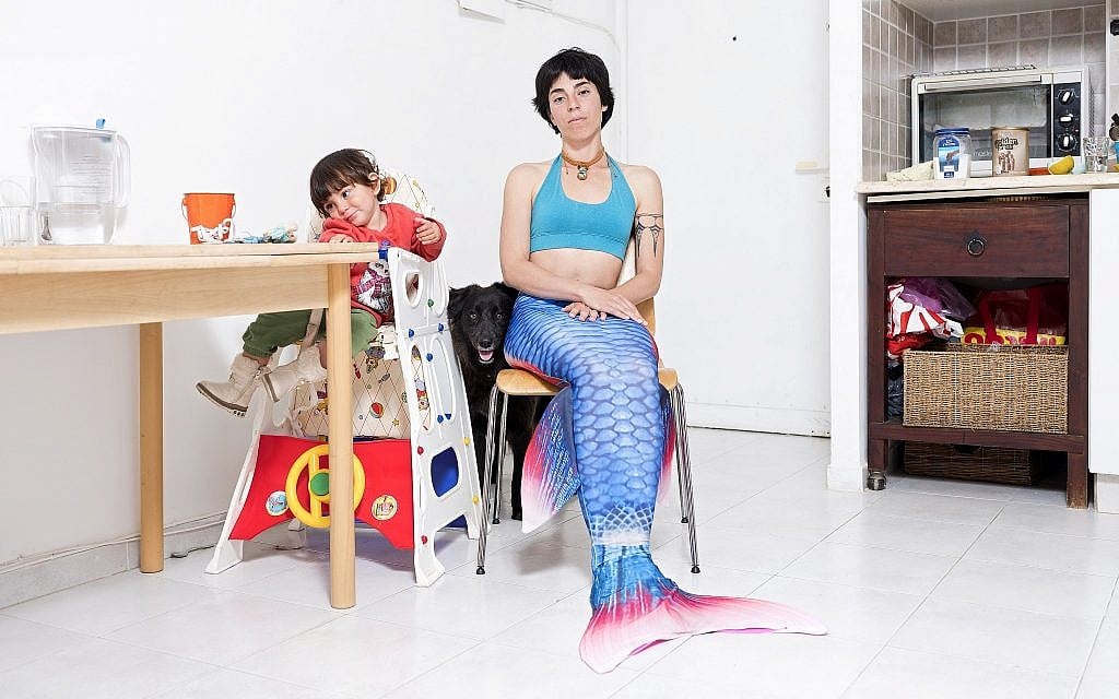 In this Tuesday, Feb. 26, 2019 photo, Ommer Globerman, a member of the Israeli Mermaid Community, poses for a portrait as she wears a mermaid tail at her home in Ashkelon, Israel. (AP Photo/Oded Balilty)