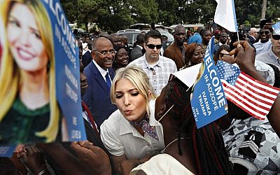 White House senior adviser Ivanka Trump is greeted by kisses as she is welcomed by local people holding U.S. flags and small flags that say "Welcome In Adzope Ivanka Trump We Love U," in Adzope, Ivory Coast, Wednesday April 17, 2019, where she will visit Cayat, a cocoa and coffee cooperative. Trump is in Ivory Coast to promote a White House global economic program for women. (AP Photo/Jacquelyn Martin)