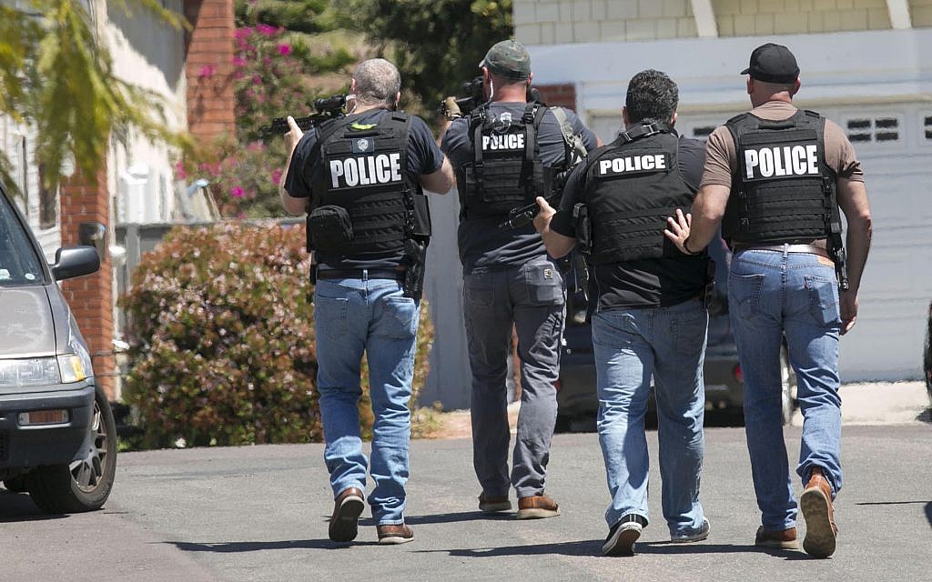 Heavily armed San Diego police officers approach a house thought to be the home of 19-year-old John T. Earnest, the alleged shooter in the fatal attack at a synagogue in Poway on April 27, 2019, in San Diego, California. (John Gibbins/ The San Diego Union-Tribune via AP) Heavily armed San Diego police officers approach a house thought to be the home of 19-year-old John T. Earnest, the alleged shooter in the fatal attack at a synagogue in Poway on April 27, 2019, in San Diego, California. (John Gibbins/ The San Diego Union-Tribune via AP)