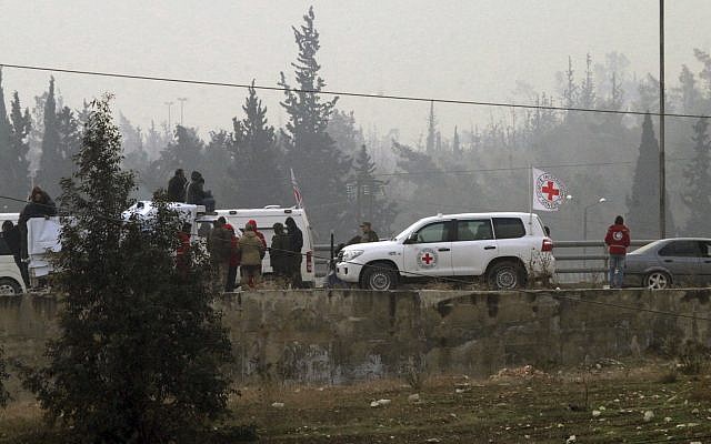 In this photo released by the Syrian official news agency SANA, civilians gather near the Red Cross vehicles for evacuation from eastern Aleppo, Syria, Friday, Dec. 16, 2016. (SANA via AP) In this photo released by the Syrian official news agency SANA, civilians gather near the Red Cross vehicles for evacuation from eastern Aleppo, Syria, Friday, Dec. 16, 2016. (SANA via AP)