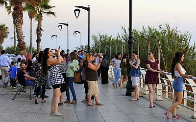 Tourists takes pictures, as the sun sets over the Mediterranean Sea in Beirut, Lebanon, on June 30, 2017. (AP Photo/Hassan Ammar/File)
