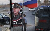 Syrian army soldier stands at a check-point as Russian military police vehicle, right, passes by near the village of Almajdiyeh, Syria, Tuesday, Aug. 14, 2018. (AP/Sergei Grits)