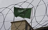 Illustrative: A Saudi flag behind barbed wire. (AP Photo/Petros Giannakouris)