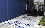 Law enforcement officers investigate racist and anti-Semitic graffiti in front of a building that houses the Oklahoma Democratic Party headquarters Thursday, March 28, 2019, in Oklahoma City. Former Democratic Gov. David Walters said Thursday that vandals spray-painted derogatory remarks about various racial and ethnic groups outside the building. Swastikas were also spray-painted onto the doors. Walters and his wife, Rhonda, own the building, which also houses other tenants. (AP Photo/Adam Kealoha Causey)