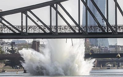 A large water fountain rises behind the Iron Bridge when a 250 kilogram American bomb from World War II in the Main River is detonated with a blast in Frankfurt, Germany, April 14, 2019. (Frank Rumpenhorst/dpa via AP)