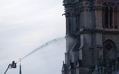 Firefighters tackle the blaze as flames and smoke rise from Notre Dame cathedral as it burns in Paris, Monday, April 15, 2019. (AP Photo/Thibault Camus)