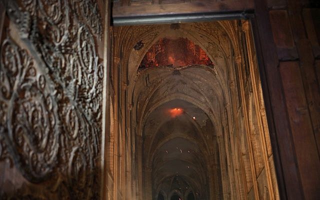 Smoke and flames are seen in the interior of Notre Dame cathedral in Paris, Monday, April 15, 2019.  (Philippe Wojazer/Pool via AP)