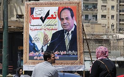 People walk past a banner supporting proposed amendments to the Egyptian constitution with a poster of Egyptian President Abdel-Fattah el-Sissi in Cairo, Egypt, April 16, 2019. (AP/Amr Nabil)