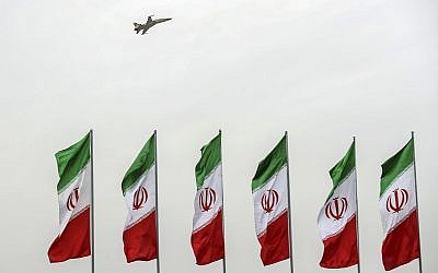 In this photo released by the official website of the office of the Iranian Presidency, a fighter jet flies over Iranian flags during the army parade commemorating National Army Day in front of the shrine of the late revolutionary founder Ayatollah Khomeini, just outside Tehran, Iran on April 18, 2019. (Iranian Presidency Office via AP)