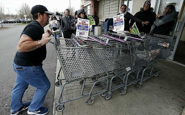 A temporary worker rolls shopping carts past striking workers outside a Stop & Shop supermarket in Boston, Thursday, April 18, 2019. (AP/Michael Dwyer) A temporary worker rolls shopping carts past striking workers outside a Stop & Shop supermarket in Boston, Thursday, April 18, 2019. (AP/Michael Dwyer)
