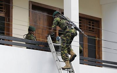 A Sri Lankan police commando enters a house suspected to be a hideout of militants following a shoot out in Colombo, Sri Lanka, on April 21, 2019. (AP/Eranga Jayawardena)