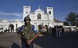 Sri Lankan air force officers and clergy stand outside St. Anthony's Shrine, a day after a blast in Colombo, Sri Lanka, April 22, 2019. (AP Photo/Gemunu Amarasinghe)