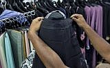A salesman covers the face of a mannequin with a niqab cafe veil at a women's clothing shop in Kattankudy, Sri Lanka, April 29, 2019. (AP/Gemunu Amarasinghe)
