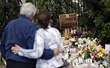 A couple embrace near a growing memorial across the street from the Chabad of Poway synagogue in Poway, California, April 29, 2019 (AP Photo/Greg Bull)