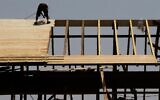 Illustrative: A construction worker on a rooftop at a construction site in downtown Jerusalem on August 5, 2015. (Nati Shohat/Flash90)
