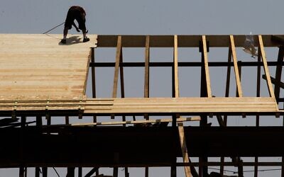 Illustrative: A construction worker on a rooftop at a construction site in downtown Jerusalem on August 5, 2015. (Nati Shohat/Flash90)