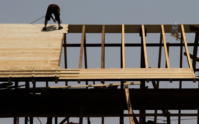 Illustrative: A construction worker on a rooftop at a construction site in downtown Jerusalem on August 5, 2015. (Nati Shohat/Flash90) Illustrative: A construction worker on a rooftop at a construction site in downtown Jerusalem on August 5, 2015. (Nati Shohat/Flash90)