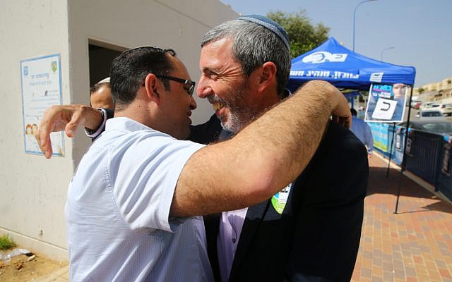 Rafi Peretz, leader of the right-wing Jewish Home party (right), hugs a supporter outside a voting station in the southern town of Sderot on April 9, 2019. (Flash90) Rafi Peretz, leader of the right-wing Jewish Home party (right), hugs a supporter outside a voting station in the southern town of Sderot on April 9, 2019. (Flash90)
