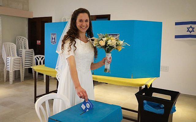 Bride Tsufit Lam casts her ballot at a voting station in the West Bank settlement of Elazar during Knesset elections, on April 9, 2019. (Gershon Elinson/Flash90) Bride Tsufit Lam casts her ballot at a voting station in the West Bank settlement of Elazar during Knesset elections, on April 9, 2019. (Gershon Elinson/Flash90)