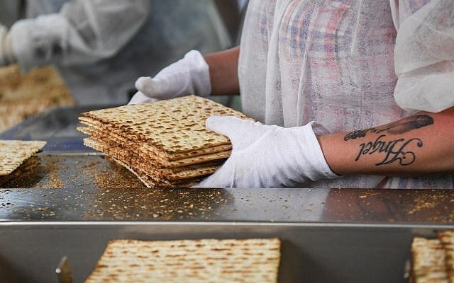 Illustrative: Workers prepare matzah, the unleavened bread eaten during the Jewish holiday of Passover, at the Aviv Matzah plant in Bnei Brak on April 14, 2019. (Flash90) Illustrative: Workers prepare matzah, the unleavened bread eaten during the Jewish holiday of Passover, at the Aviv Matzah plant in Bnei Brak on April 14, 2019. (Flash90)