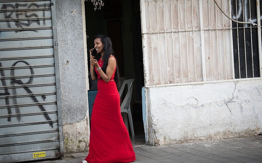 A woman in a red dress walking in south Tel Aviv. (Hadas Porush/Flash90)