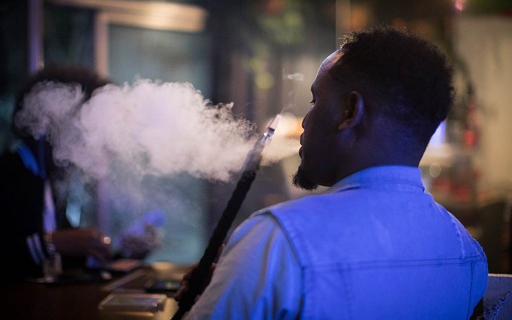 A man smokes nargila in Jimmy's cafe. (Hadas Porush/Flash90)