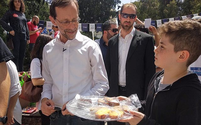 Sixth grade students in Tel Aviv holding a bake sale to raise money for their end of year party show off their baked goods to Zehut party candidate Moshe Feiglin outside a voting booth on April 9, 2019. Feiglin did not support the bake sale. (Melanie Lidman/Times of Israel) Sixth grade students in Tel Aviv holding a bake sale to raise money for their end of year party show off their baked goods to Zehut party candidate Moshe Feiglin outside a voting booth on April 9, 2019. Feiglin did not support the bake sale. (Melanie Lidman/Times of Israel)