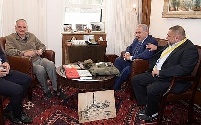 Prime Minister Benjamin Netanyahu, center, and Dr. Ido Netanyahu, left, receive the personal effects of their brother Yoni in Jerusalem on April 15, 2019. (Amos Ben-Gershom/GPO)