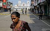 A Sri Lankan woman walks on a road leading to St. Anthony's Church, one of the sites of Easter Sunday's bomb attacks in Colombo, Sri Lanka, April 25, 2019. (AP/Eranga Jayawardena)