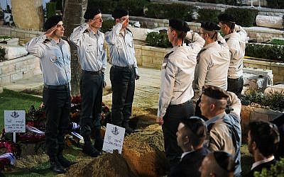 Illustrative: Israeli soldiers salute near the fresh grave of Zachary Baumel, during his funeral at the Mount Herzl Military cemetery in Jerusalem, April 4, 2019. (Hadas Parush/Flash90)
