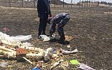 Workers use discarded plastic to pick up debris from the scene where an Ethiopian Airlines Boeing 737 crashed shortly after takeoff last month, killing all 157 on board, near Bishoftu, Ethiopia in April 2019. (Courtesy)
