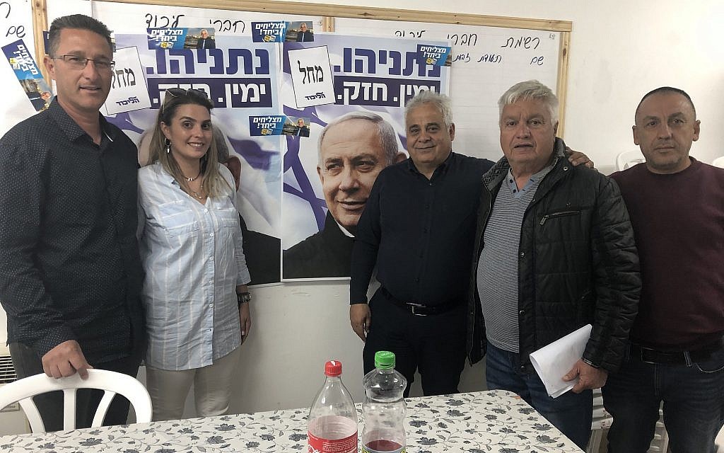 Benny Biton, mayor of Dimona (third from right), poses with fellow Likud activists at the Likud party's campaign headquarters, Dimona, April 8, 2019. (Sue Surkes/Times of Israel.)