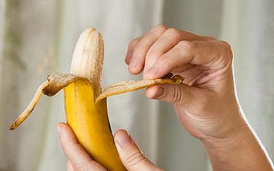 Illustrative photo of a person peeling a banana. (iStock)