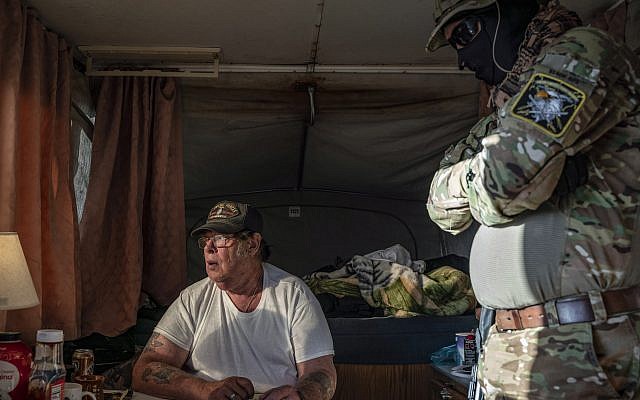 Larry Hopkins, seated, also known as Striker, the leader of the United Constitutional Patriots New Mexico Border Ops militia, inside the team's camper near the US-Mexico border in Anapra, New Mexico, March 20, 2019. (Paul Ratje/AFP/Getty Images via JTA) Larry Hopkins, seated, also known as Striker, the leader of the United Constitutional Patriots New Mexico Border Ops militia, inside the team's camper near the US-Mexico border in Anapra, New Mexico, March 20, 2019. (Paul Ratje/AFP/Getty Images via JTA)