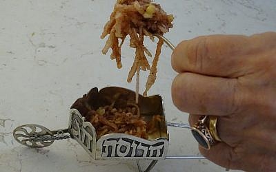 Passover delicacy haroset being spooned into a small silver wagon, used by some Jews to serve the dish. (The Toby Press)