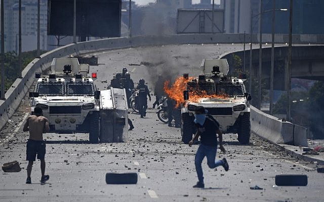 Supporters of Venezuelan opposition leader and self-proclaimed acting president Juan Guaido clash with forces loyal to President Nicolas Maduro after members of the Bolivarian National Guard joined Guaido's campaign to oust him, in front of La Carlota military base in Caracas on April 30, 2019. (Federico Parra/AFP)