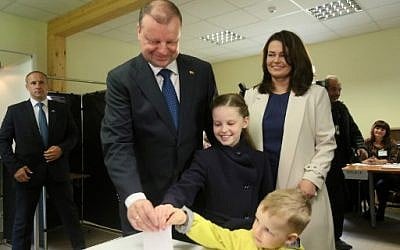Lithuanian presidential candidate Prime Minister Saulius Skvernelis, his wife Silvija Skverneliene and their children cast a ballot during the presidential election in Vilnius on May 12, 2019.  (Photo by Petras Malukas / AFP)