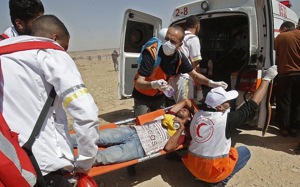 Palestinian medics carry a wounded demonstrator east of Khan Yunis in the southern Gaza Strip on May 15, 2019, during a Nakba protest. (Said KHATIB / AFP)