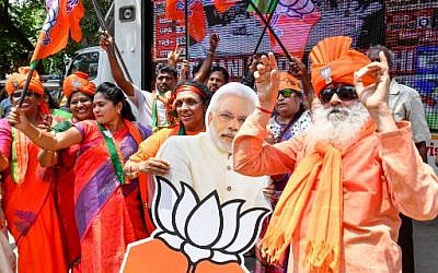 Indian supporters and party workers of the Bharatiya Janata Party (BJP) in Bangalore dance and hold flags as they celebrate the results of India's general election on May 23, 2019. (Manjunath Kiran/AFP)