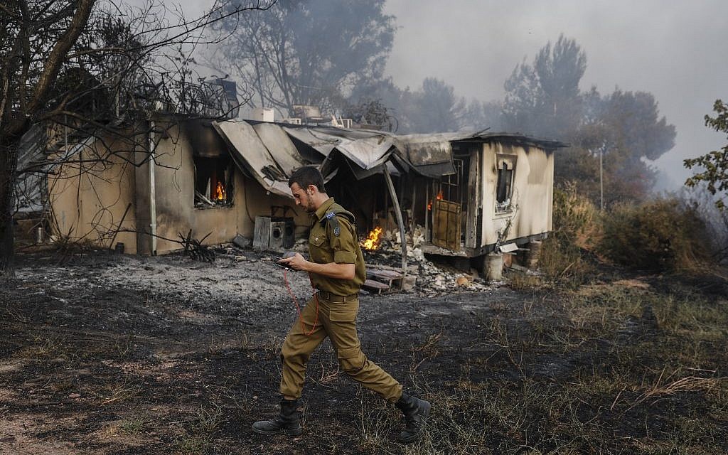 An Israeli soldier walks past a burning house amid extreme heat wave in Kibbutz Harel in central Israel on May 23, 2019. (Ahmad GHARABLI / AFP)