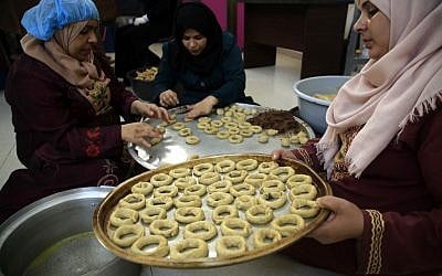 Palestinian women prepare traditional cookies ahead of the Eid al-Fitr festivities, celebrating the end of the holy Muslim fasting month of Ramadan, in Beit Lahia in the northern Gaza Strip on May 29, 2019. (MOHAMMED ABED / AFP)