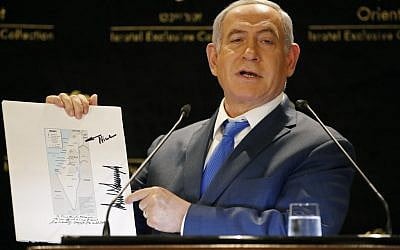 Prime Minister Benjamin Netanyahu displays a map of Israel indicating the Golan Heights are inside the state's borders, signed by US president Donald Trump on May 30, 2019. (Thomas COEX / AFP)