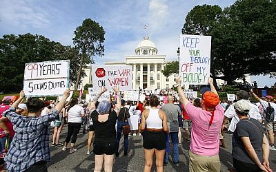 Protesters for women's rights hold a rally on the Alabama Capitol steps to protest a law passed last week making abortion a felony in nearly all cases with no exceptions for cases of rape or incest, Sunday, May 19, 2019, in Montgomery, Ala. (AP Photo/Butch Dill)