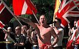 In this July 18, 1998, file photo, Karl Wolf raises his arm in a Nazi salute as he marches through the streets of Coeur d'Alene, Idaho, where scores of police in riot gear stood between parading white supremacists and protesters who jeered at the Aryan Nations marchers. (AP Photo/Elaine Thompson, File)
