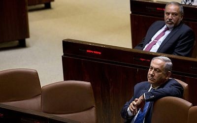 Prime Minister Benjamin Netanyahu (front) and former Defense Minister Avigdor Liberman sit in the Knesset, May 23, 2016. (AP Photo/Sebastian Scheiner, File)