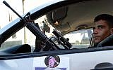 Zakaria Zubeidi, then the local commander of Fatah's terrorist wing, the Al-Aqsa Martyrs Brigades, sits in a car decorated with a poster of former Palestinian leader Yasser Arafat, in the northern West Bank town of Jenin, December 2, 2004. (AP Photo/Mohammed Ballas)