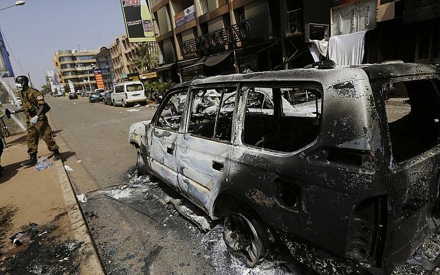 Illustrative: A soldier walks past a burnt car in front of Cappuccino cafe in Ouagadougou, Burkina Faso, after it was attacked by al-Qaeda-linked extremists, January 17, 2016. (Sunday Alamba/AP) Illustrative: A soldier walks past a burnt car in front of Cappuccino cafe in Ouagadougou, Burkina Faso, after it was attacked by al-Qaeda-linked extremists, January 17, 2016. (Sunday Alamba/AP)