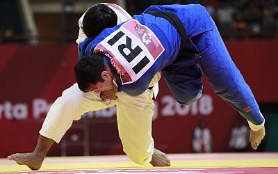 Uzbekistan's Bekmurod Oltiboev, in white, competes against Iran's Javad Mahjoub during their men's +100 kg judo bronze medal match at the 18th Asian Games in Jakarta, Indonesia, August 31, 2018. (AP/Dita Alangkara)