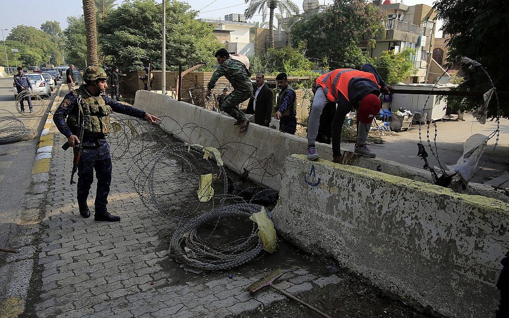 Iraqi security forces remove concrete blast walls leading to the heavily guarded Green Zone in Baghdad, Iraq, Nov. 27, 2018. (AP/Karim Kadim)